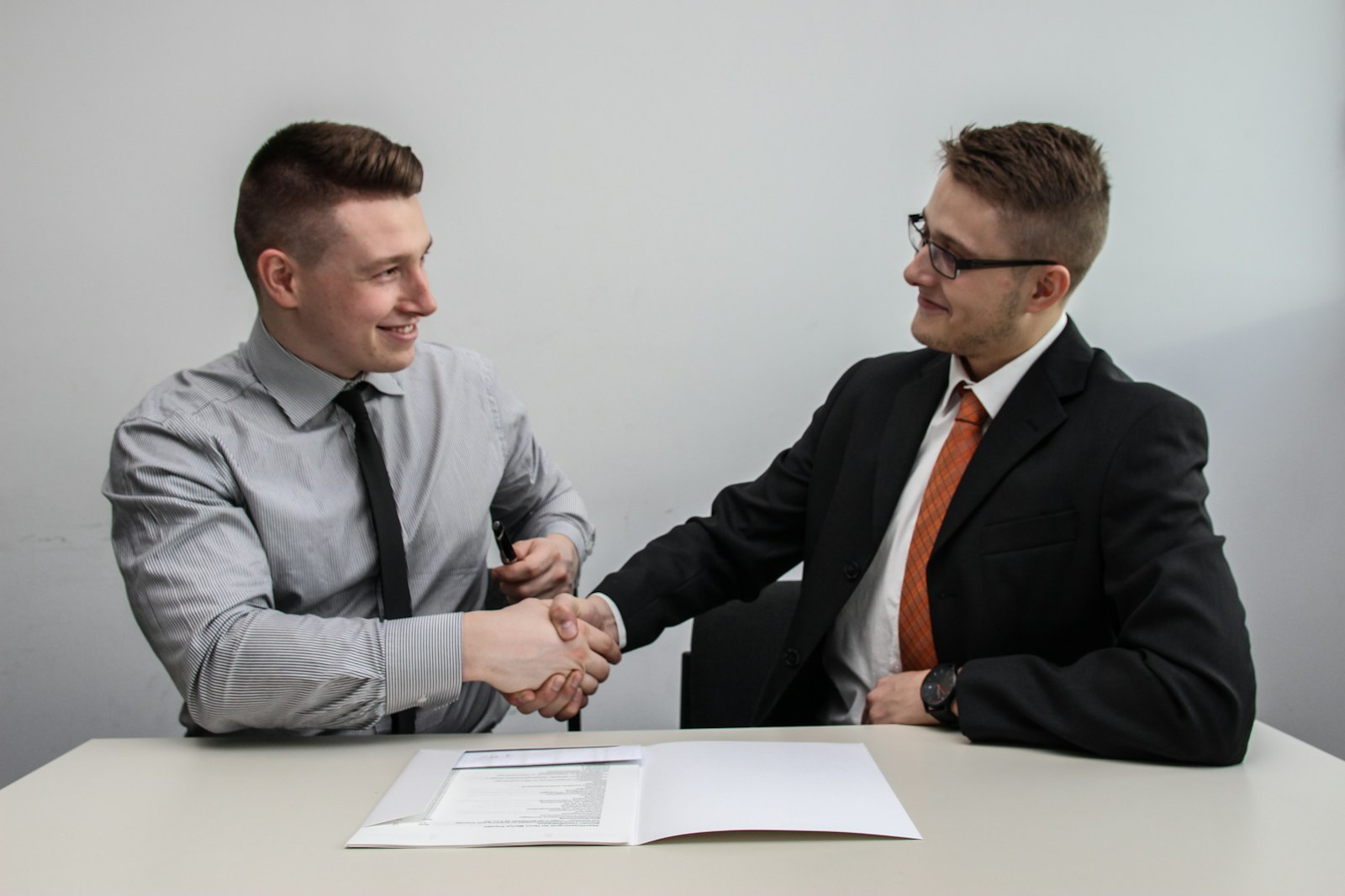 two professionals shaking hands and smiling