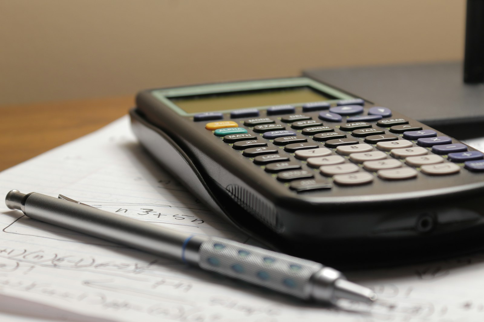 calculator and house model representing buying costs