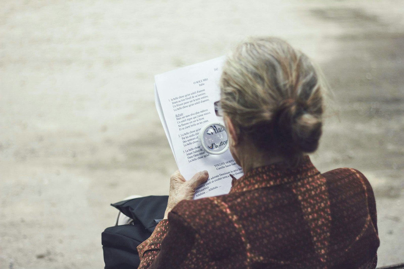 a woman reading a printed document closely