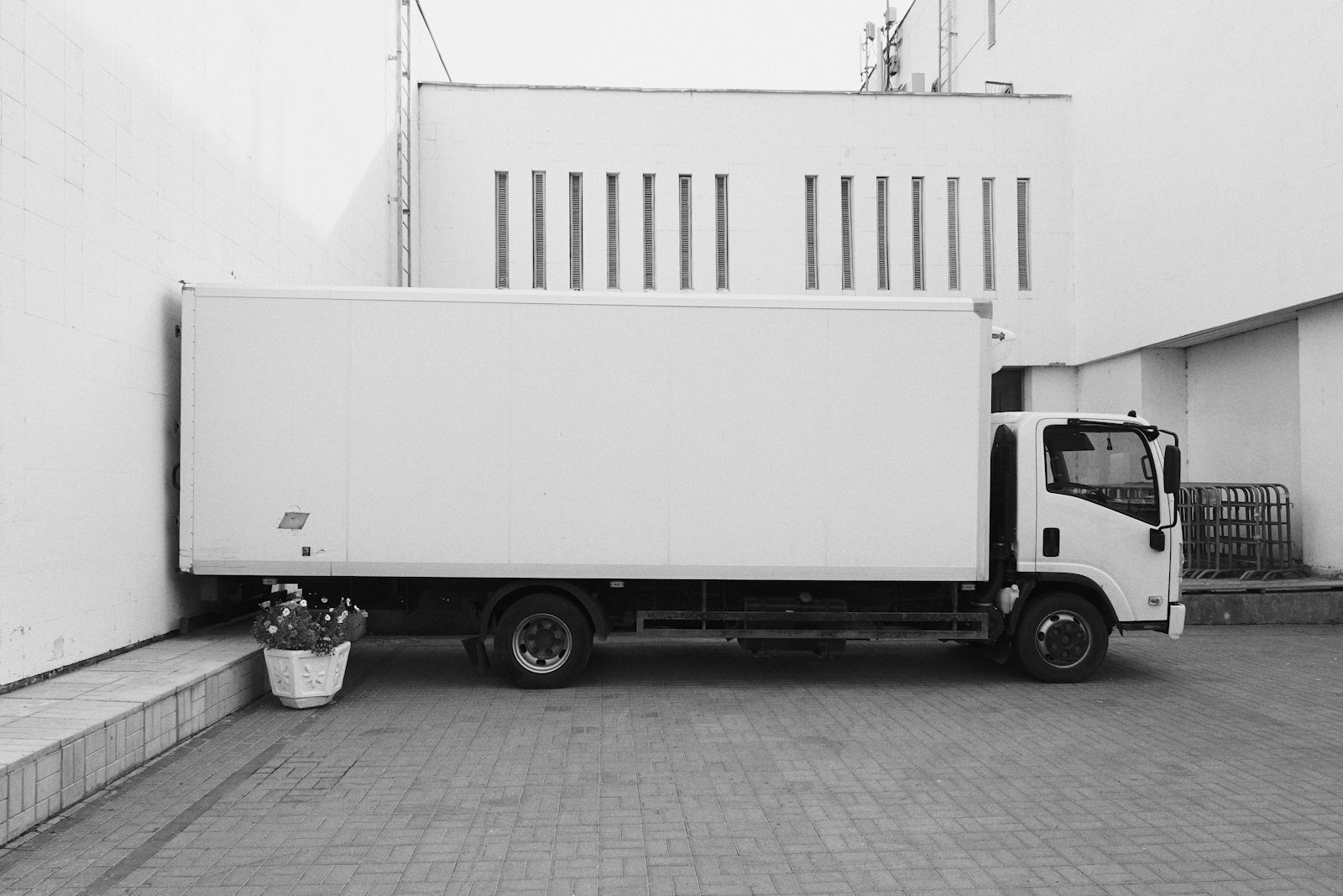 a white truck parked near a white building