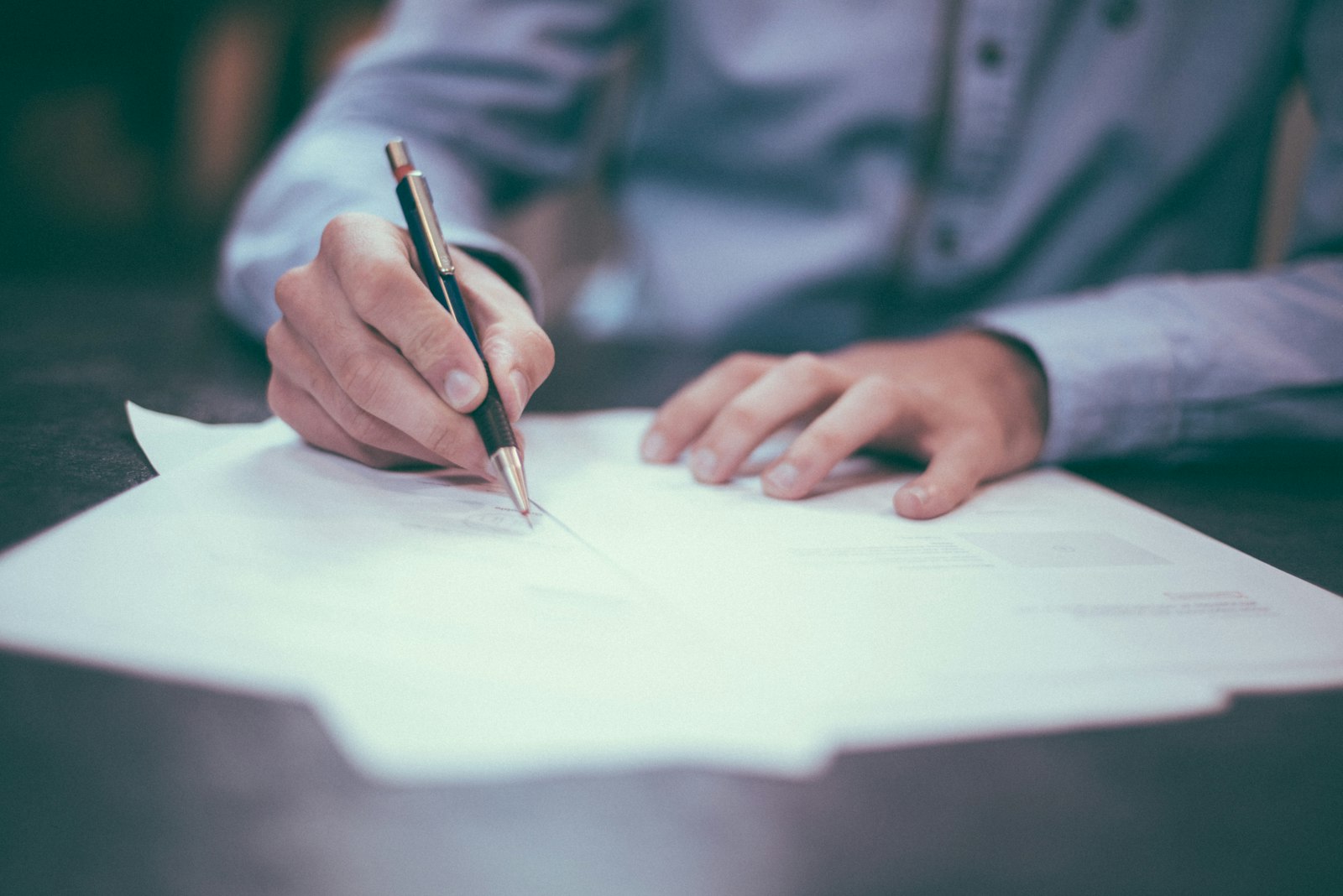 person signing a property sale and purchase agreement