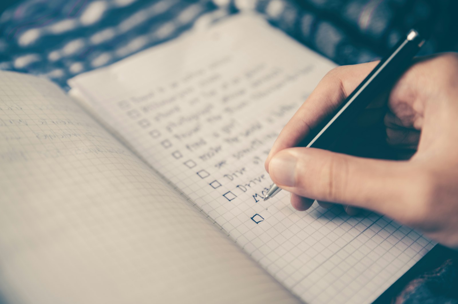 a person writing a list on a notebook