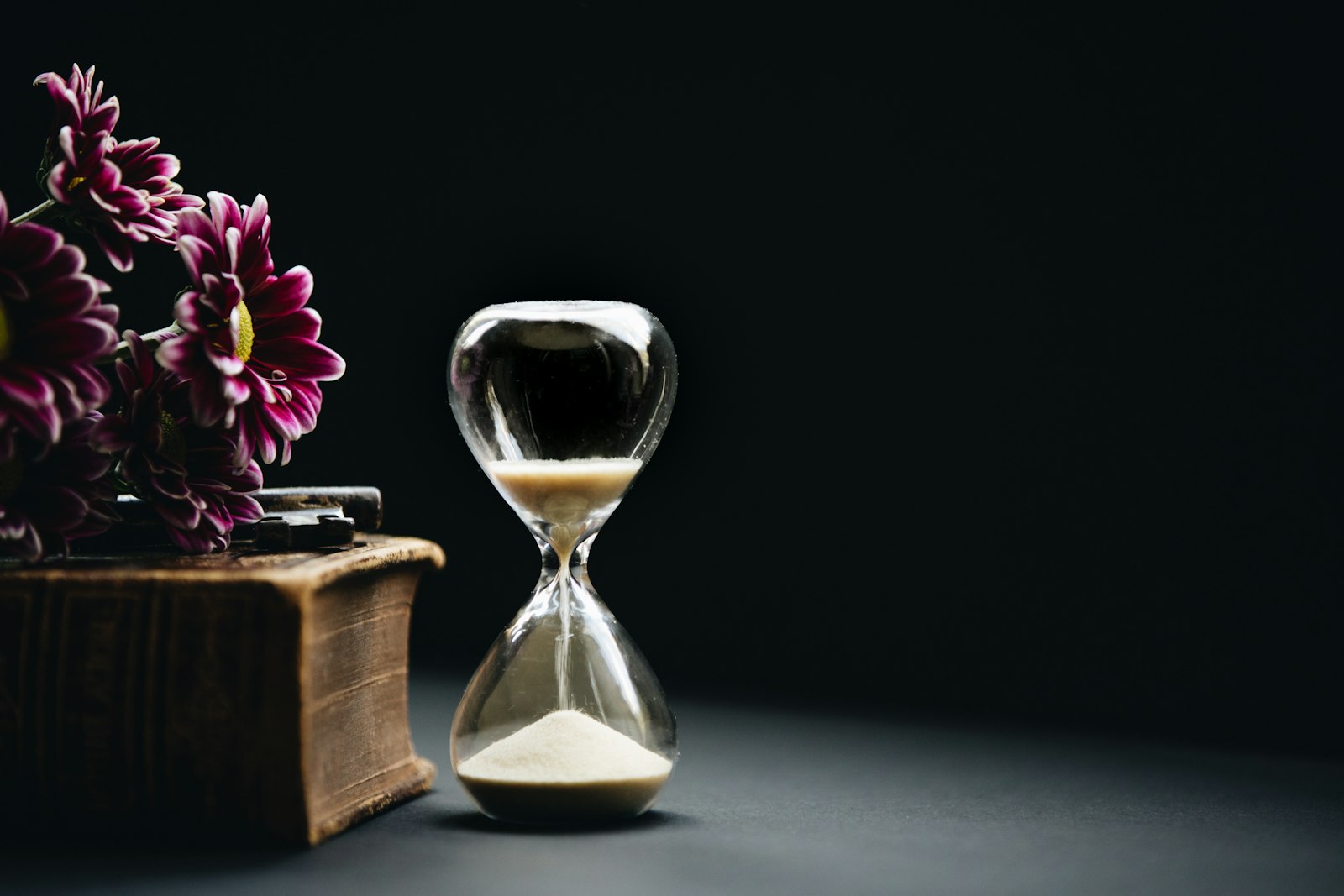 hourglass timer beside flowers representing a property buying timeline