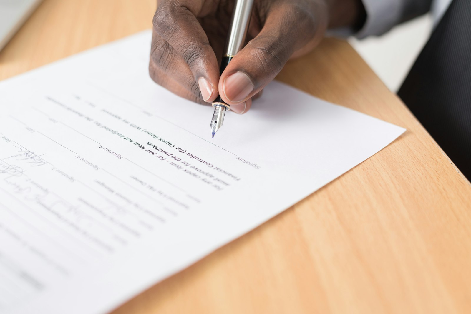 a person writing on white paper